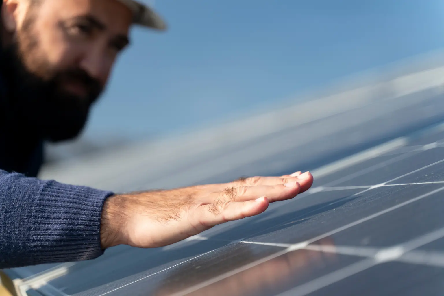 Operario cualificado revisando la superficie de un panel solar fotovoltaico durante el montaje